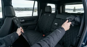 Hands installing a waterproof dog car seat cover using quick-release buckles, perfect for fast setups in cold Canadian weather.