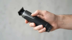 Close-up of an ergonomic Dremel-style electric dog nail grinder being held securely during a nail session.